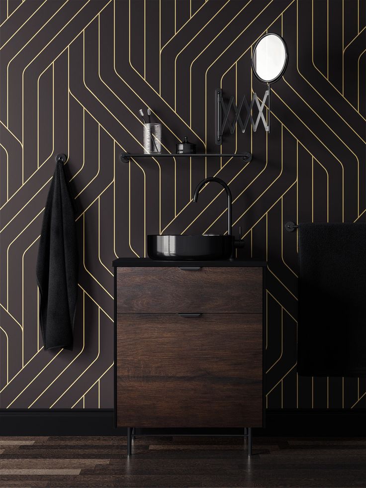 a black and gold geometric wallpaper with a wooden cabinet in the corner next to it