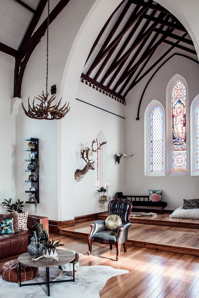 a living room filled with furniture and a stained glass window