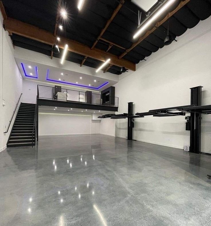 an empty room with stairs and lights on the ceiling