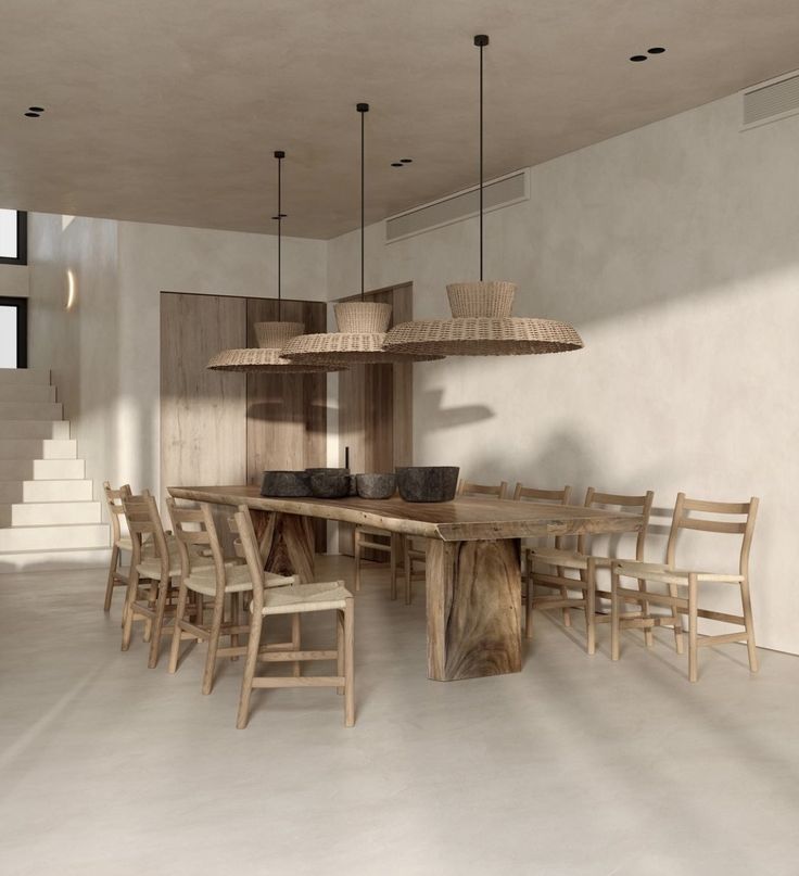 a large wooden table surrounded by chairs in a room with white walls and flooring