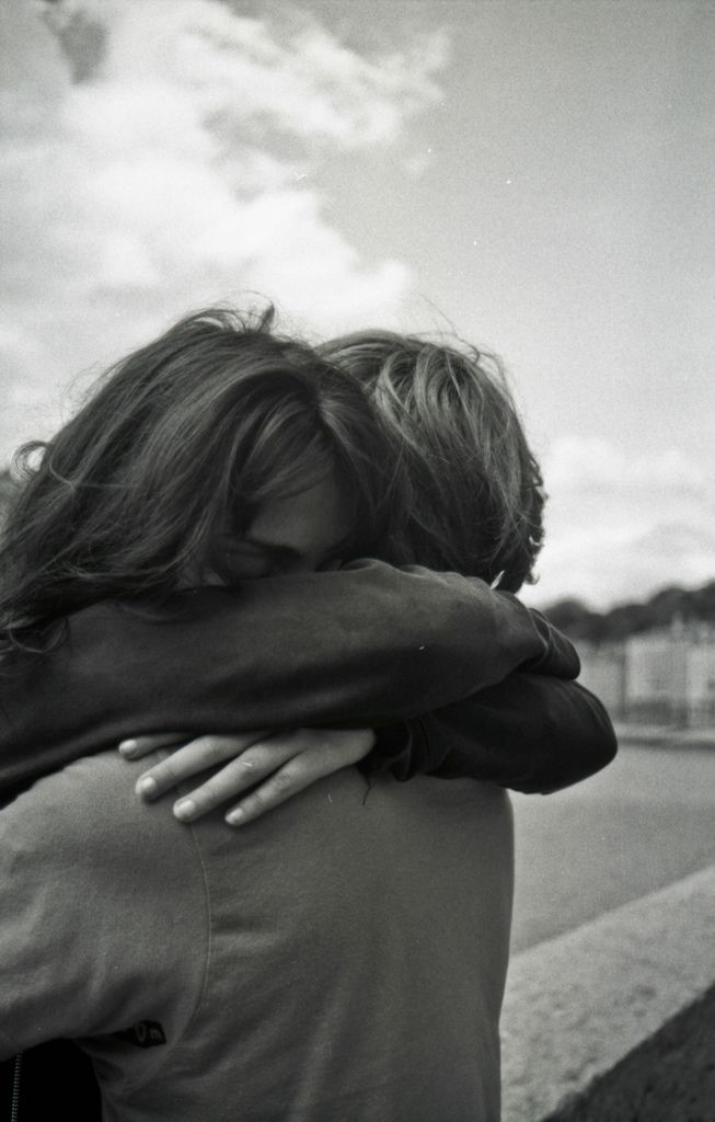 black and white photograph of two people hugging each other