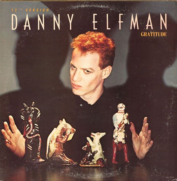 an album cover with a man holding his hands up in front of him and other figurines