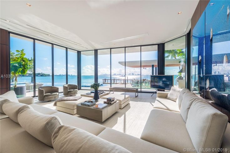 a living room filled with furniture and large windows