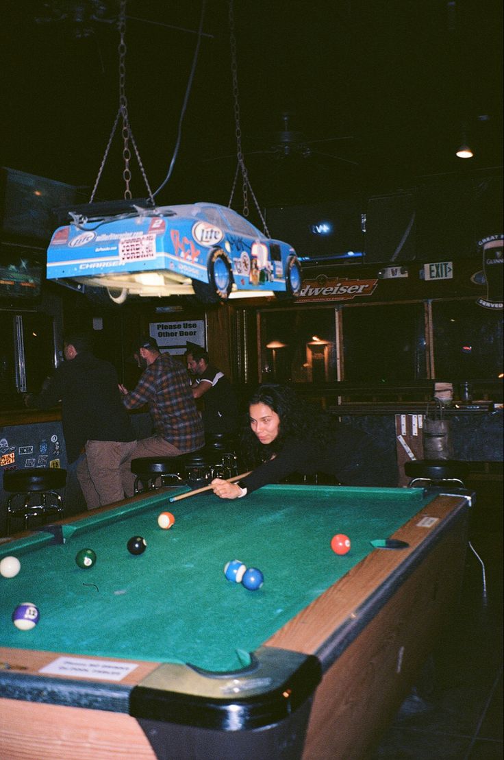 a man is playing pool in a bar