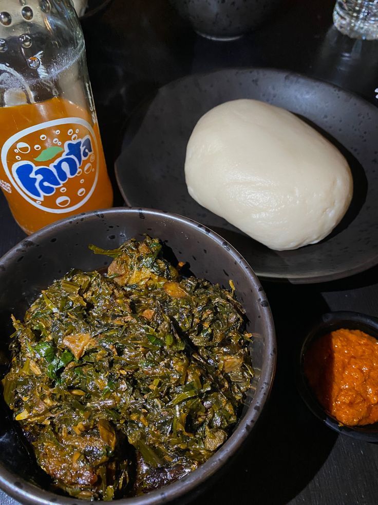 there is a bowl of food on the table next to some sauces and a bottle