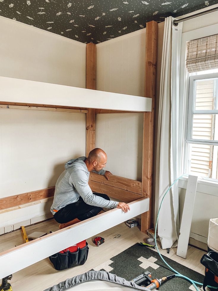 a man sitting on top of a bunk bed