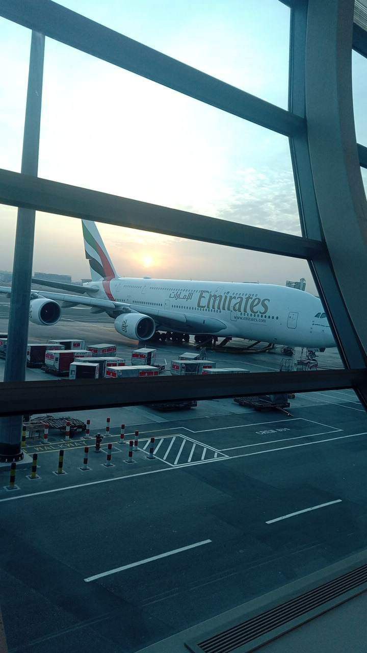 an airplane sitting on the tarmac next to a window at an air port terminal