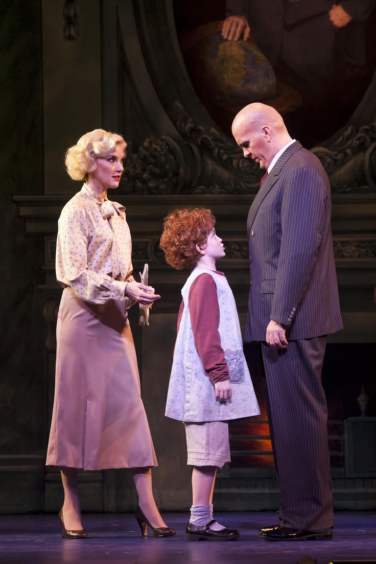 an older man standing next to two women on a stage with one holding a microphone