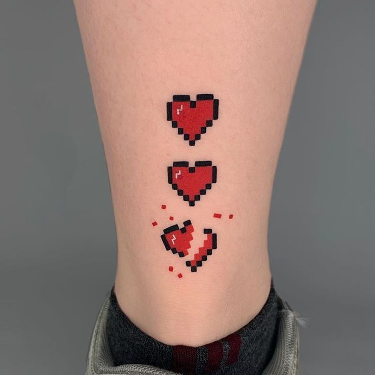 a woman's leg with pixel heart tattoos on her left side ribcage