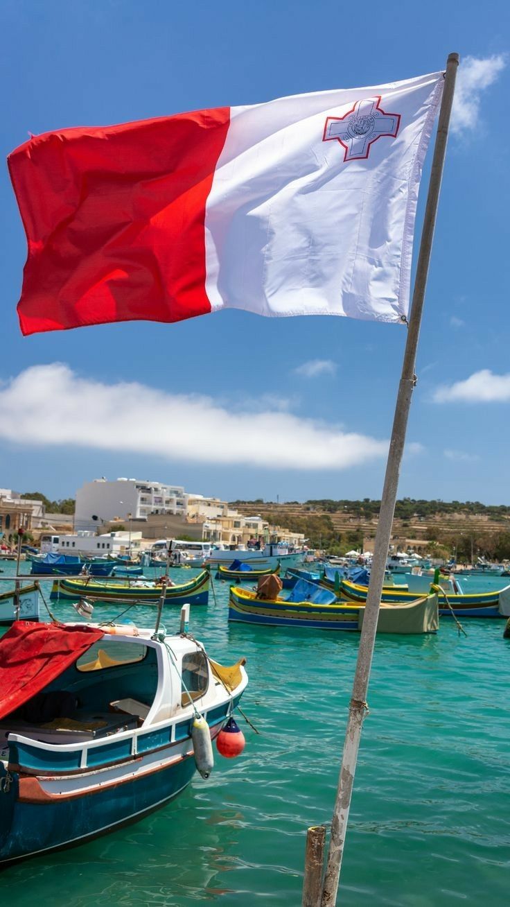 an italian flag flying over boats in the water