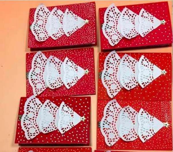 six pieces of red and white paper with lace bows on them sitting on a table