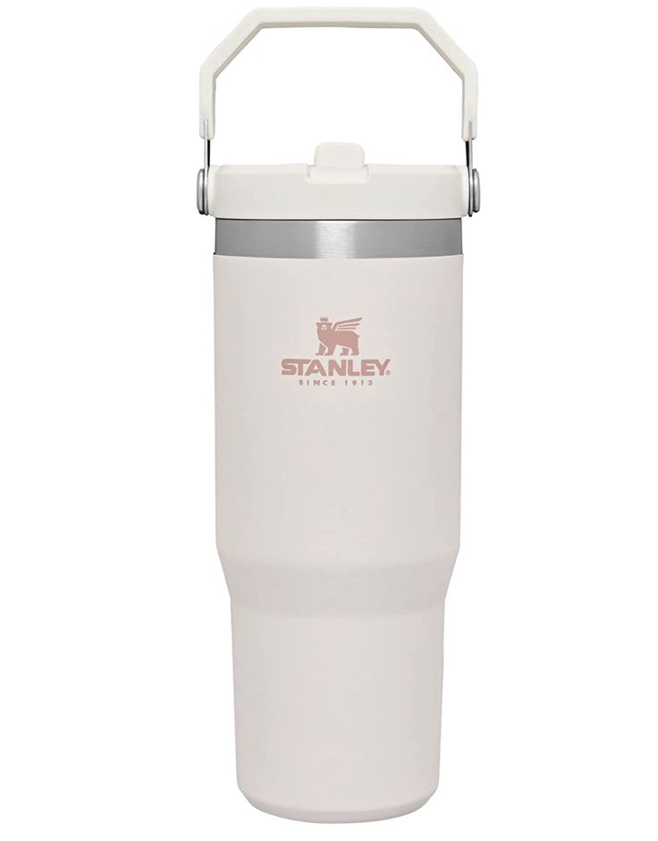 the stanley travel mug is white and has a metal handle