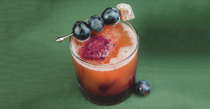 a drink with blueberries on the rim