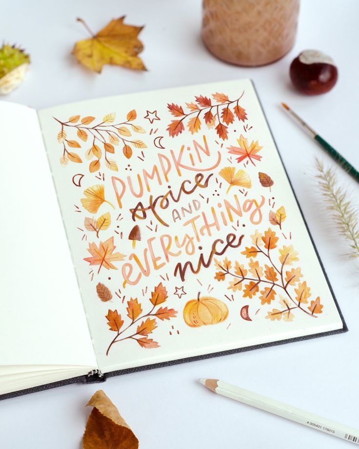 an open book with the words pumpkin spice and everything nice written on it next to autumn leaves