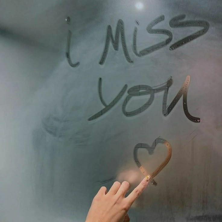 a person writing on a blackboard that says miss you