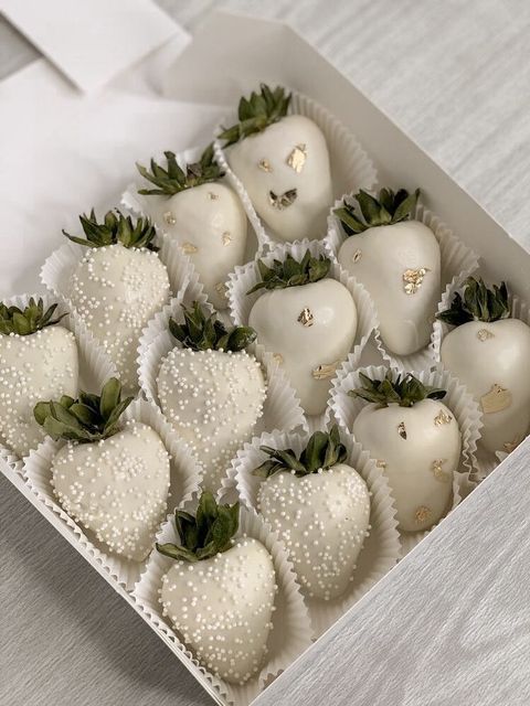 a box filled with white chocolate covered strawberries