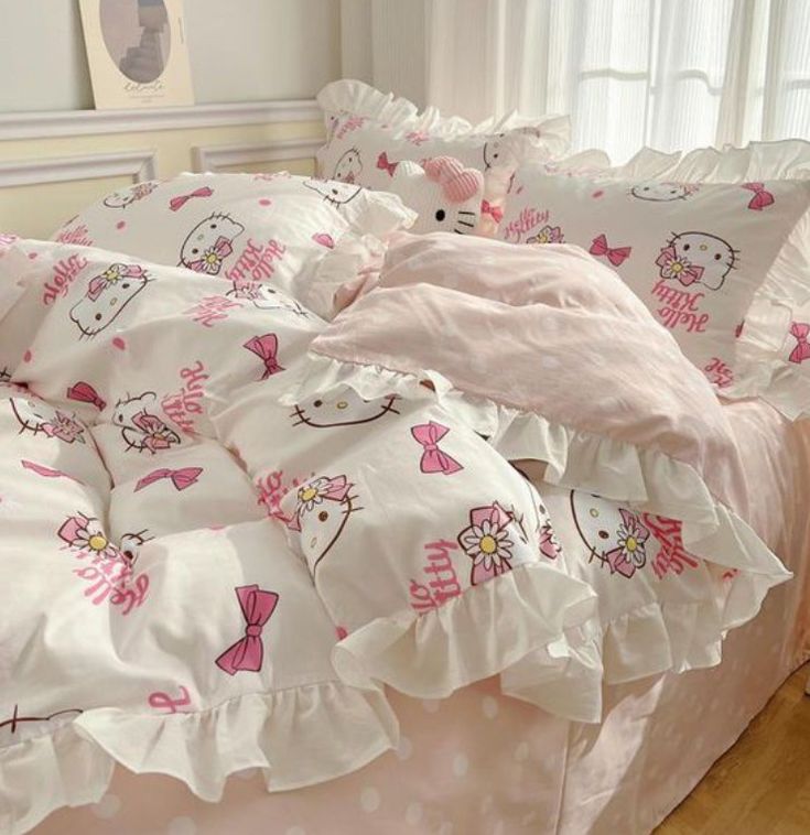 a hello kitty bed with pink and white comforter, pillows, and pillowcases