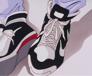 a pair of black and white sneakers with red accents on them are seen from above