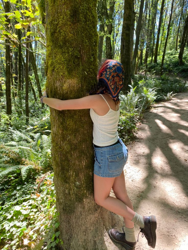 a woman climbing up the side of a tree