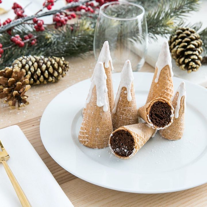 three cones with white icing are on a plate