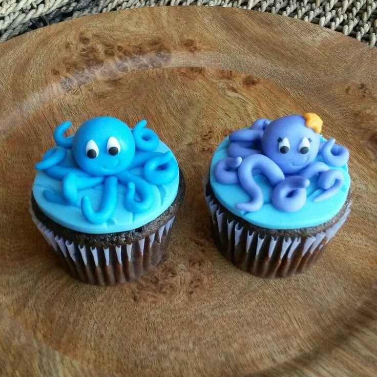 two cupcakes decorated with blue icing and an octopus