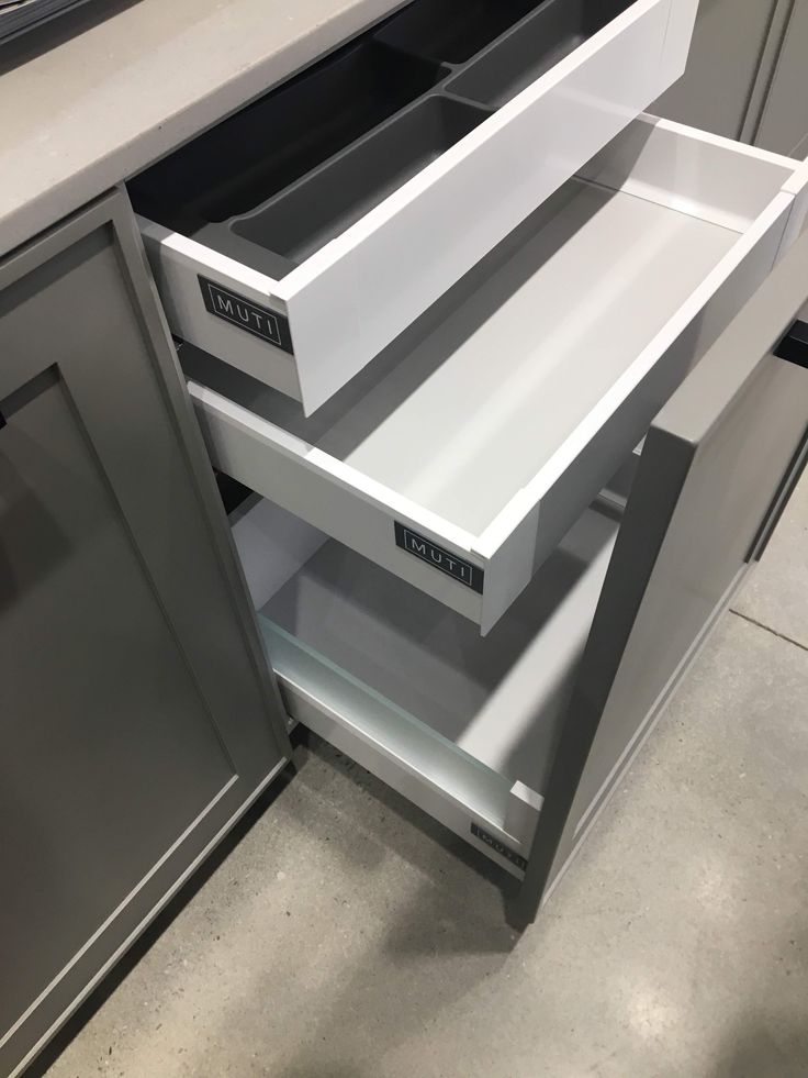 an open drawer in the middle of a kitchen counter top with drawers on both sides