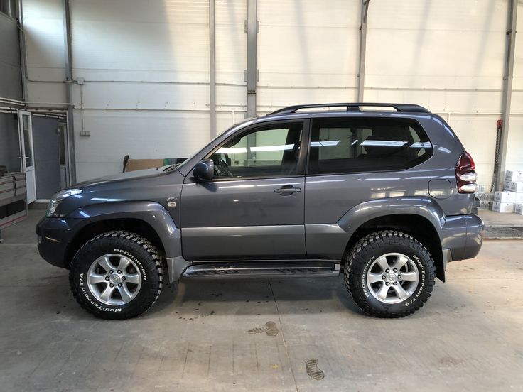 a gray suv parked in a garage next to another vehicle