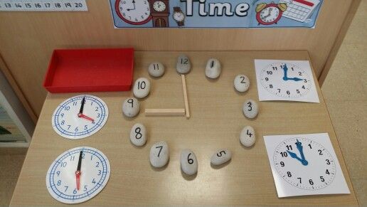 a wooden table topped with clocks and magnets