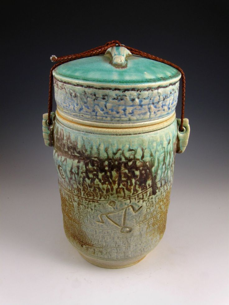 a ceramic container with handles and handle on the top is blue, green and brown