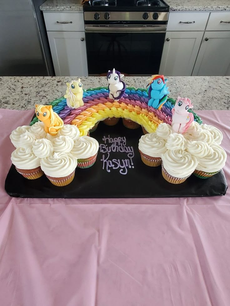 cupcakes with frosting and rainbow decorations on a table