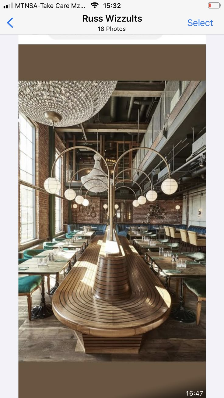 an empty restaurant with wooden tables and green chairs, chandeliers hanging from the ceiling