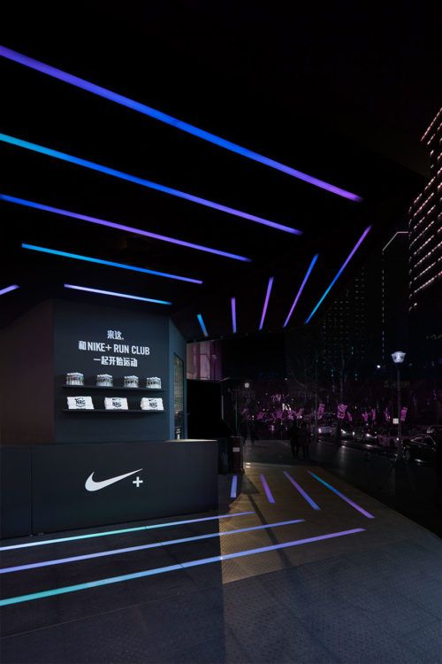 the entrance to nike hong kong club is lit up with blue and purple lights at night