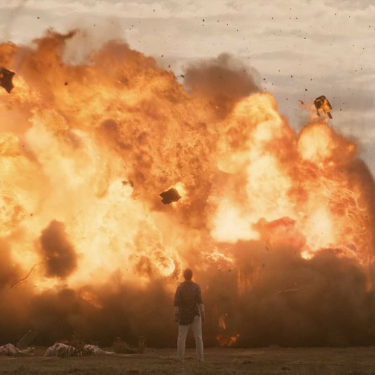 a man standing in front of a huge fire