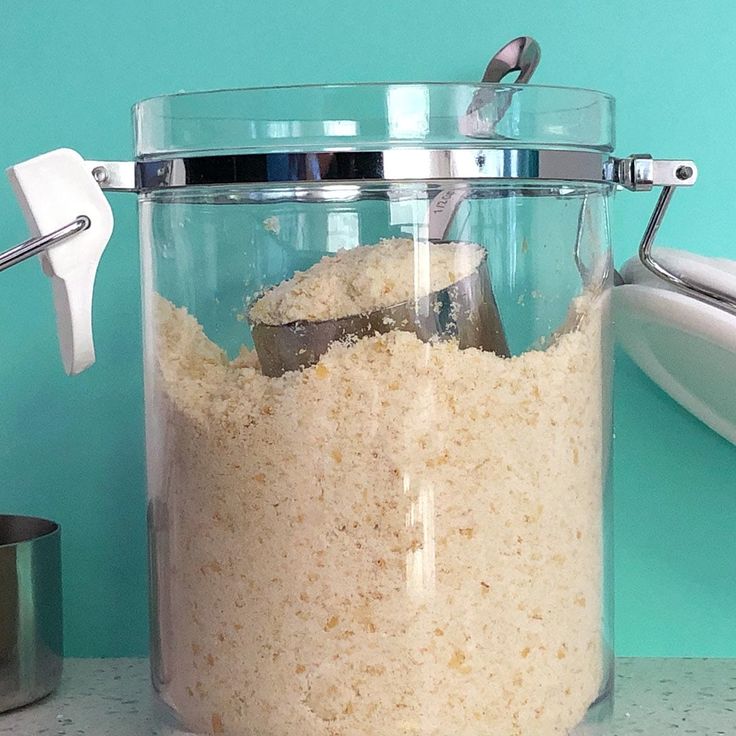 a glass jar filled with food next to a silver cup and a toothbrush on a counter