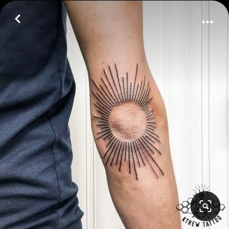 a man with a tattoo on his arm that has a sun in the middle of it