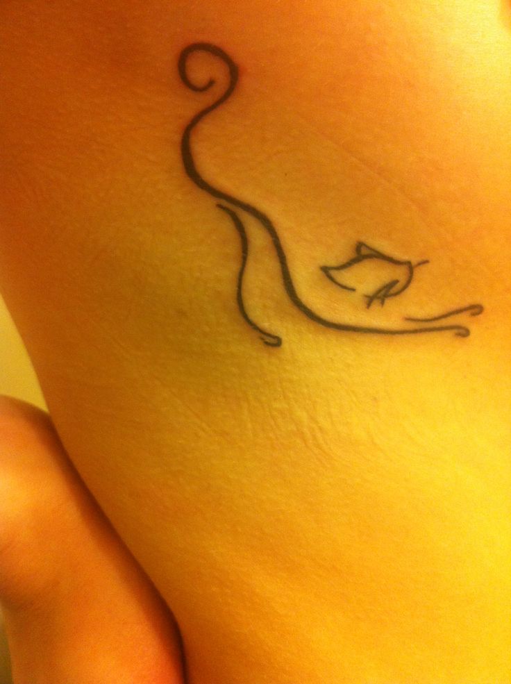 a woman's foot with a cat tattoo on the side of her leg,