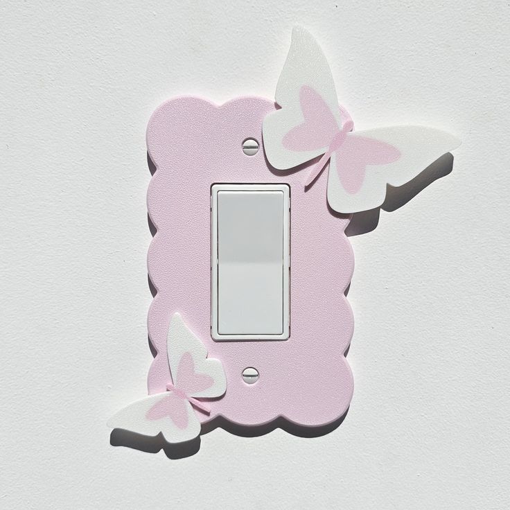 a pink light switch cover with butterflies on the back and white wall in the background