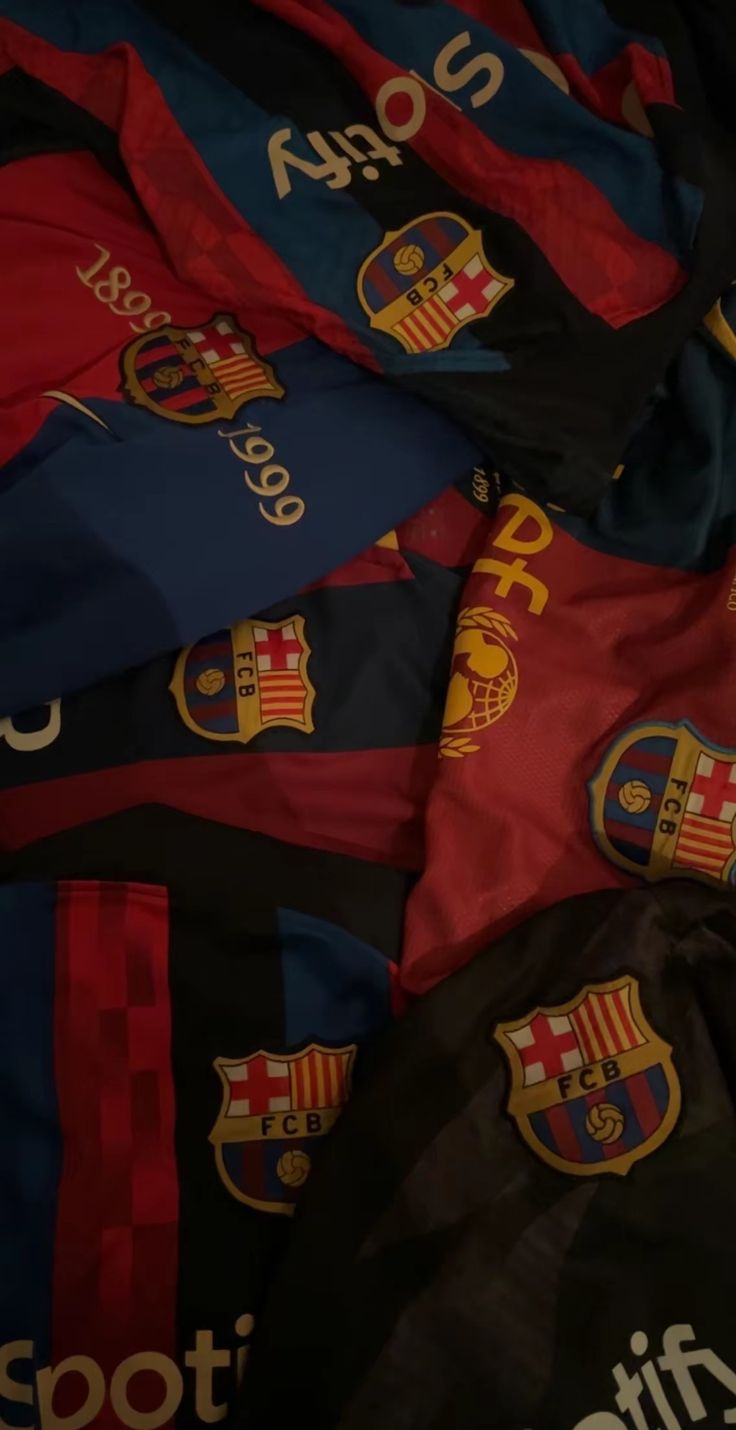 many different colored soccer jerseys laying on top of each other in a pile with the names and numbers