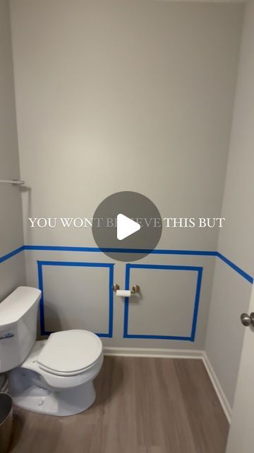 a white toilet sitting inside of a bathroom next to a walk in shower and wooden floors