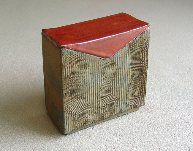 a small wooden block with a red top