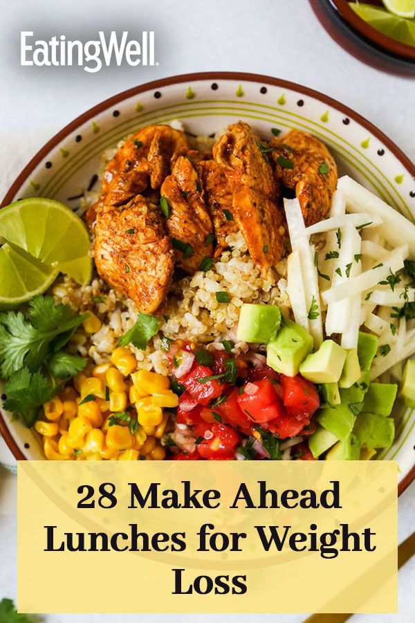 a bowl filled with chicken, rice and vegetables next to lime wedges on the side