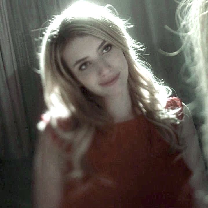 a woman in a red dress is posing for a photo with her hair blowing in the wind