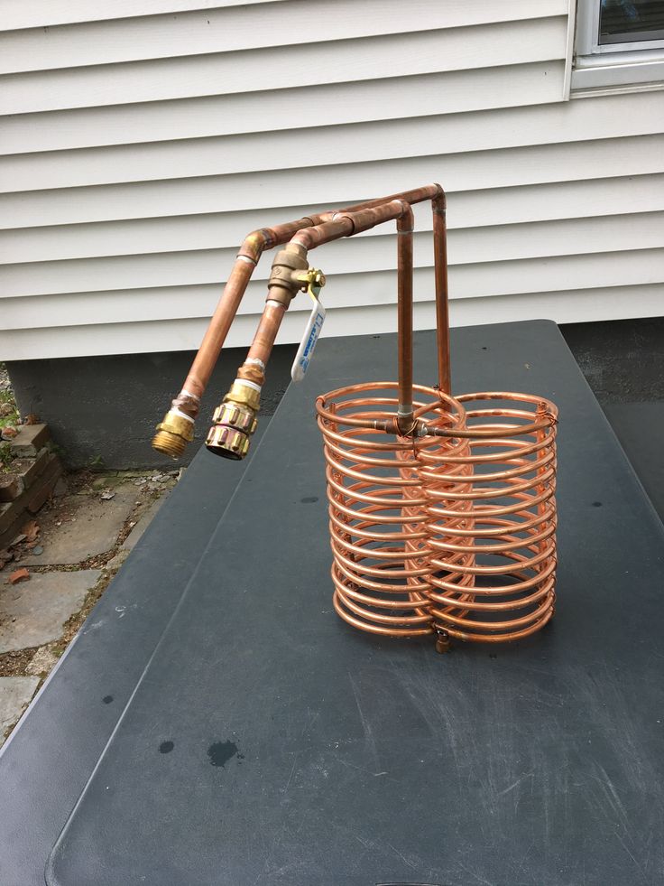 a large metal basket sitting on top of a black table next to a white house