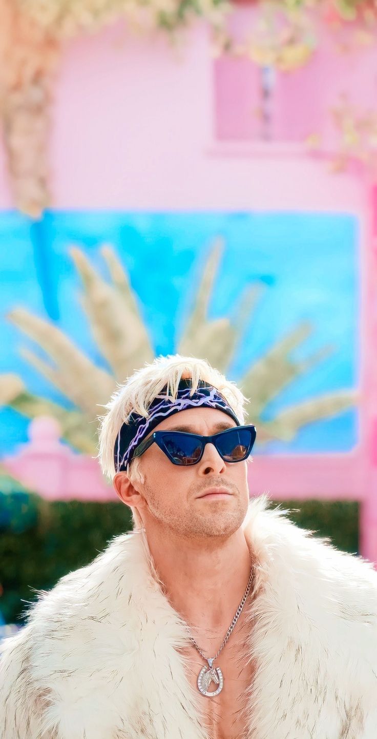 a man with white hair wearing sunglasses and a fur coat in front of a palm tree