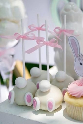 cupcakes with pink frosting and bunny ears on them are sitting on a table