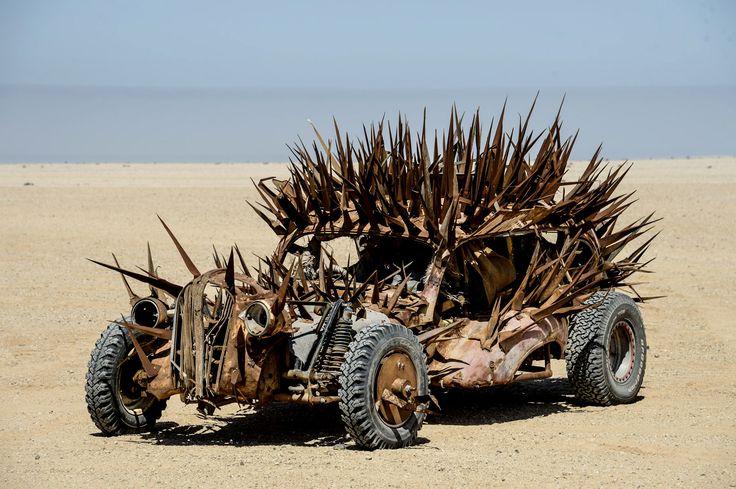 a car made out of sticks and tires in the desert