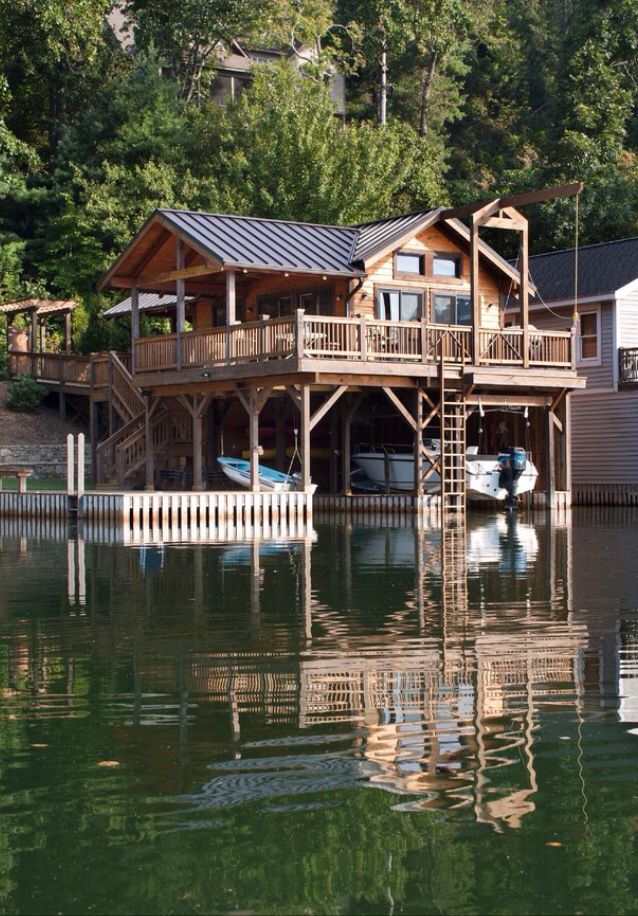 a house sitting on top of a lake surrounded by trees