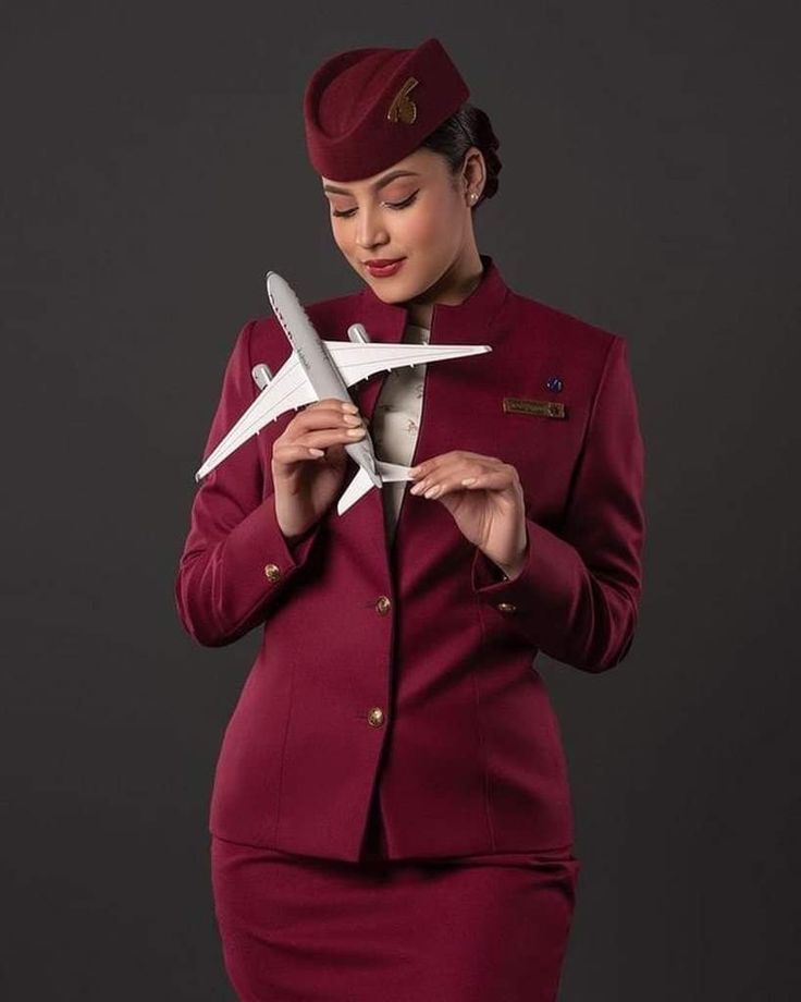 a woman in a red suit holding a white plane