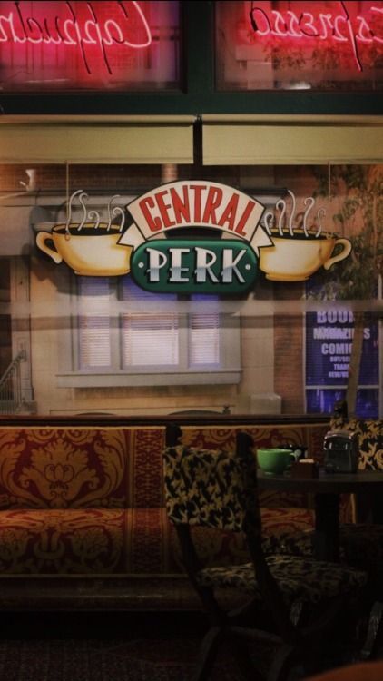 the central perk restaurant sign is lit up in red and green lights above the booth