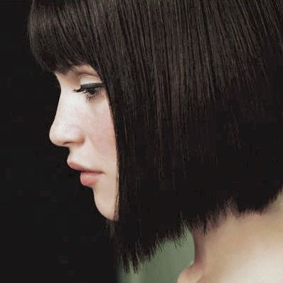 a close up of a person with a short haircut and black eyeshadow